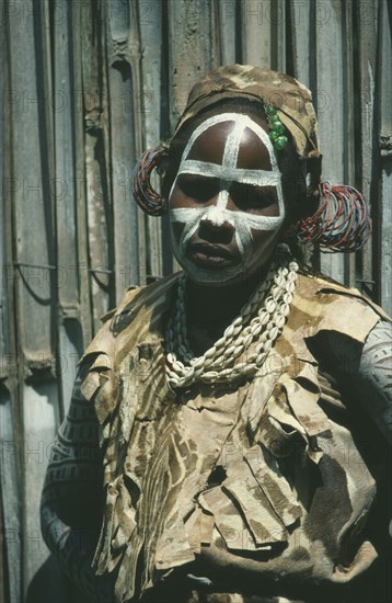 KENYA, Tribal People, Portrait of Kikuyu tribeswoman with painted face and wearing head dress for initiation ceremony.