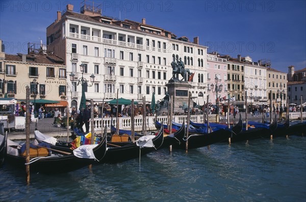ITALY, Veneto, Venice, Gondolas moored against the Riva degli Schiavoni with the Londra Palace Hotel behind.