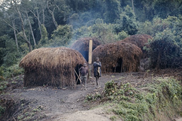 RWANDA, Traditional Housing, Circular thatched village huts with two children standing outside.
