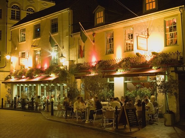 ENGLAND, East Sussex, Brighton, Donatello Italian restaurant at night in Brighton Place in The Lanes withy people dining at tables on the pavement
