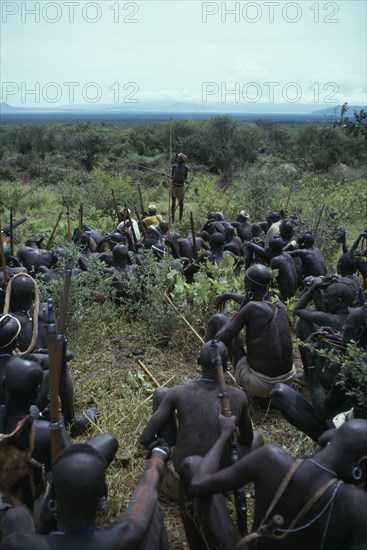 ETHIOPIA, Tribal People, Mursi tribe listening to story teller.