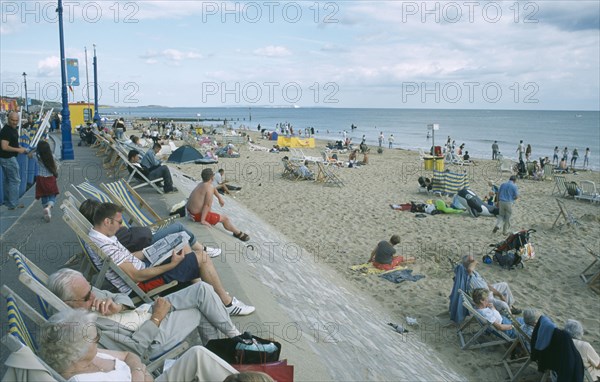 ENGLAND, Dorset, Bournemouth, People sat on deckchairs along seafront