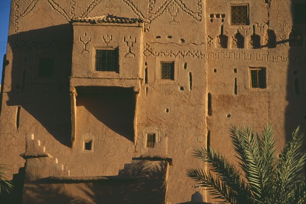MOROCCO, Ouarzazate, Kasbah Taorirt .  Nineteenth century kasbah of the el-Glaoui dynasty.  Detail of exterior wall with simple decoration and small windows with metal screens.