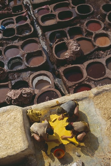 MOROCCO, Fes, Chouwara Tanneries.  Men working at the tanner’s pits with coloured dyes.