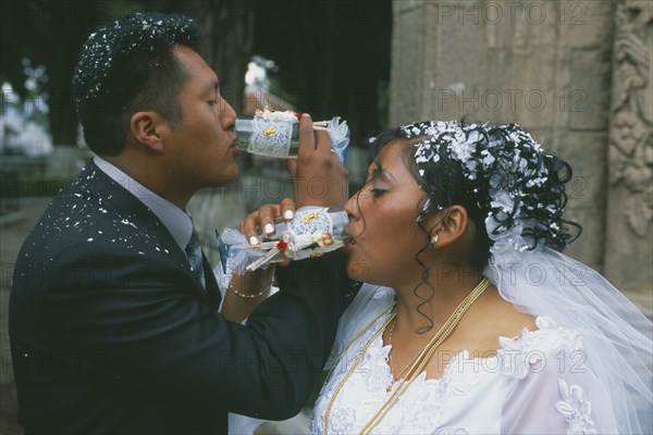 BOLIVIA, La Paz, Wedding in El Monticulo. Bride and Groom interlocking arms and drinking.