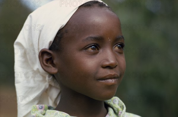 KENYA, Tribal People, "Head and shoulders portrait of young Kikuyu girl wearing headscarf, three quarter profile right."