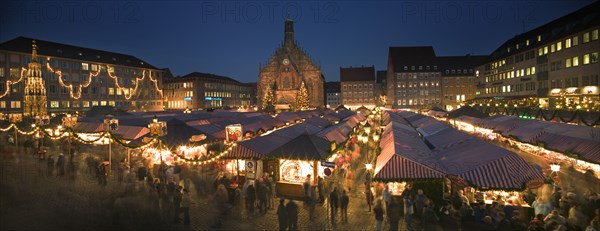 GERMANY, Bavaria, Nuremberg, Panoramic view of the Christmas Market in Hauptmarkt with The Frauenkirche behind.