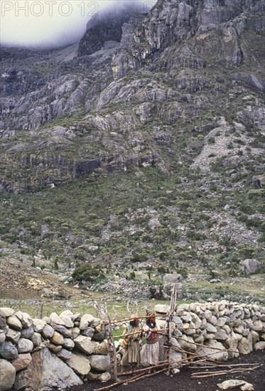 COLOMBIA, Santa Marta, Sierra Nevada , Ica man and woman looking through gate.