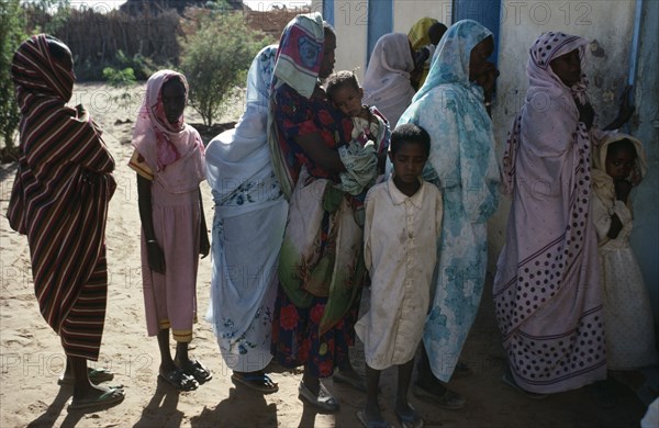 SUDAN, Asernei, Chadian refugee women and children forming queue outside Islamic African Relief Agency clinic.