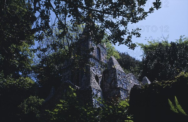 UNITED KINGDOM, Channel Islands, Guernsey, St Andrews. Les Vauxbelets.The Little Chapel seen through tree branches.