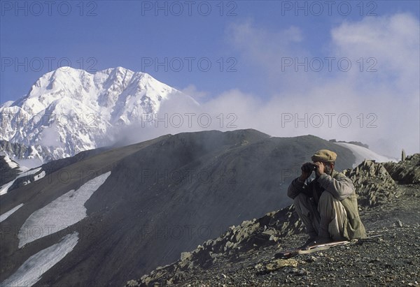 PAKISTAN, North West Frontier Province, Chitral, "Hill tribe hunter, with Tirich Mir in the background."
