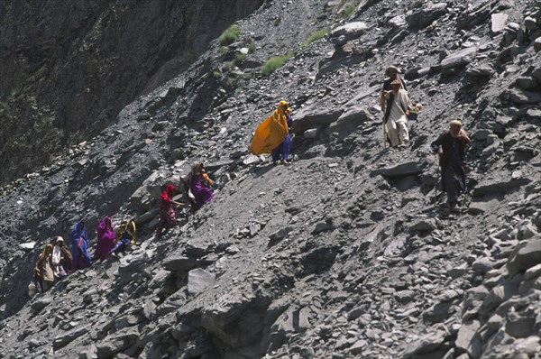 PAKISTAN, North West Frontier Province, Group of travellers negotiating a land slide on the Karakorum Highway.