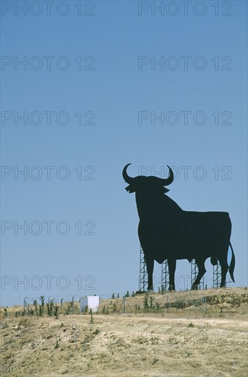 SPAIN, Andalucia, Cadiz, Large silhouette statue of a bull in a field.