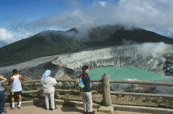 COSTA RICA, Alajuela Province, Poas Volcano, Volcan Poas National Park. View from the observation platform with tourists looking over crater.