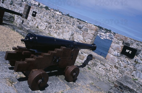 UNITED KINGDOM, Channel Islands, Guernsey, St Peter Port. Castle Cornet. Cannon next to castle wall.