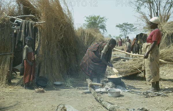 CONGO, General, Hutu village in the jungle with women cooking at open fire and watching children.