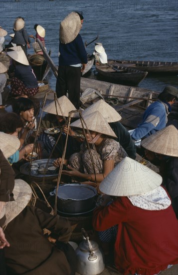 VIETNAM, Central, Hoi An, Waterside food stall and customers eating at market.