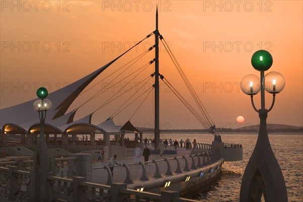 UAE, Abu Dhabi, Sun set on the Corniche promenade.