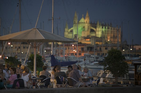 SPAIN, Balearic Islands, Mallorca, "Palma de Mallorca, Cafe with the Cathedral behind, set in the evening."