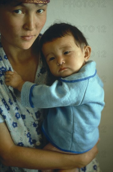 ENVIRONMENT, Aral Sea Area, Portrait of young mother holding sick baby.