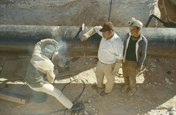 LIBYA, Work, Oil workers welding pipe.