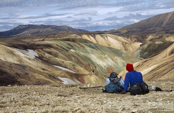 ICELAND, South Central, Colourful Rhyolite Mountains and trekkers admiring the view Landmannalaugar.