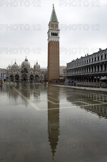ITALY, Veneto, Venice, Aqua Alta High Water flooding in St Marks Square with St marks Basilica and the Campanile reflected in the flooded piazza