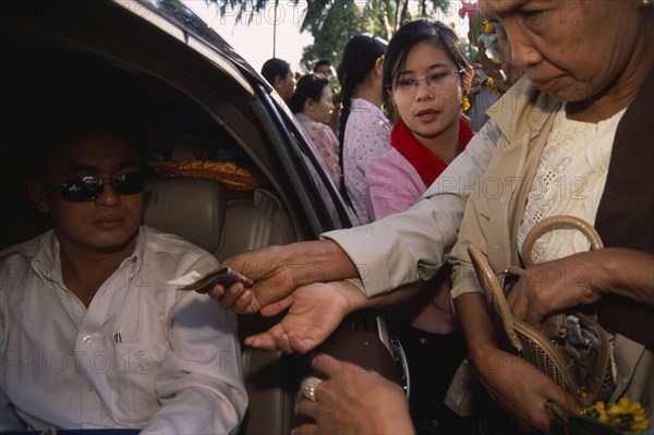 MYANMAR, Yangon, Donations being made to revered monk at Shwedagon Pagoda.