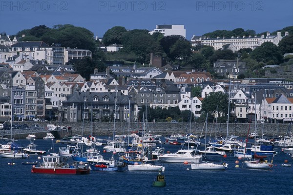 UNITED KINGDOM, Channel Islands, Guernsey, St Peter Port. View from across sea towards marina and quayside buildings.
