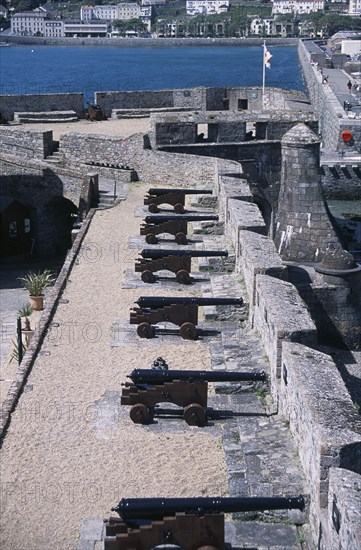 UNITED KINGDOM, Channel Islands, Guernsey, St Peter Port. Castle Cornet. Black Cannons lined up next to castle wall.