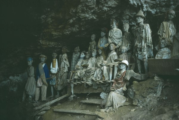 INDONESIA, Sulawesi, Toraja wooden funeral effigies or Tau Tau set into cliff cemeteries to represent the spirit of the deceased.