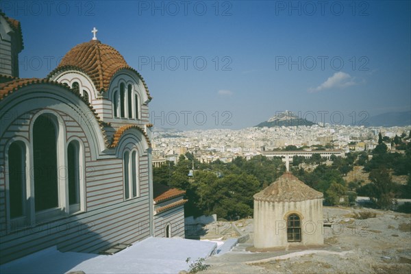 GREECE, Central, Athens, View of a church in the foreground and Acropolis and Lykavitos in the distance.