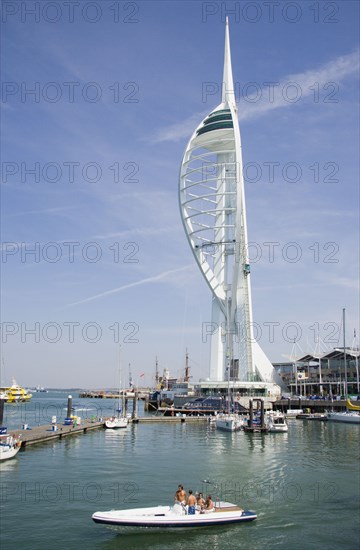 ENGLAND, Hampshire, Portsmouth, The Spinnaker Tower the tallest public viewing platforn in the UK at 170 metres on Gunwharf Quay with speedboat leaving moorings