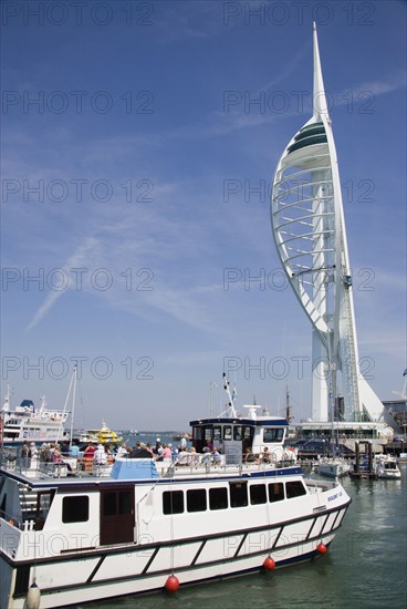 ENGLAND, Hampshire, Portsmouth, The Spinnaker Tower the tallest public viewing platforn in the UK at 170 metres on Gunwharf Quay with harbour tour boat entering moorings