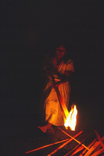 COLOMBIA, Vaupes, Tukano Indian woman lighting a fire.