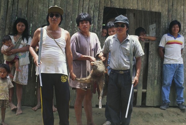 PERU, Nuevo Mundo, Camisea, Machiguenga hunters with recently killed wild boar.