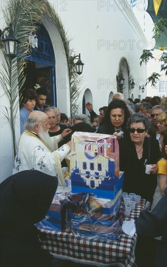 GREECE, Cyclades Islands, Santorini, Akrotiri. Annual Festival of Ayios Epiphanios. Congregation collecting wine and bread after the procession.