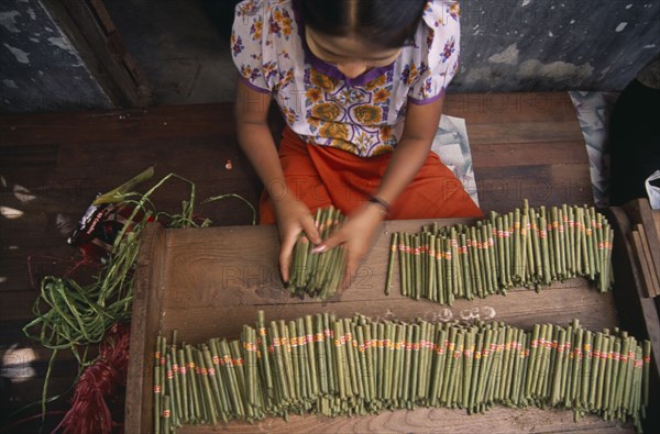 MYANMAR, Bago, Looking down on female worker in cheroot factory workplace.