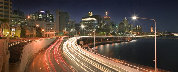 AUSTRALIA, Queensland, Brisbane, The Riverside Expressway snaking around the CBD. Car lights blurred in both directions.