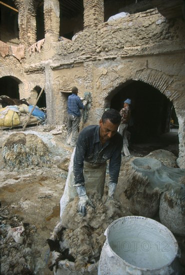 MOROCCO, Fes, Chouwara Tanneries.  Stripping fleece from skins before dyeing.