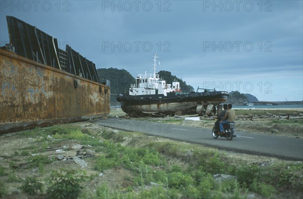 INDONESIA, Tsunami, Aceh Province, Two large metal ships dumped on middle of a road outside Banda Aceh town by wave.