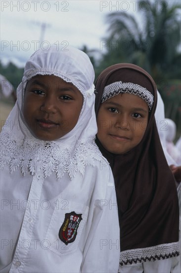 INDONESIA, Aceh Province, Two young Moslem girls in school uniform with headscarves on.