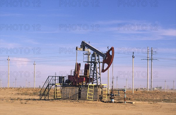 KAZAKHSTAN, Kyzlorda, Oil derrick and lots of power lines in the background.