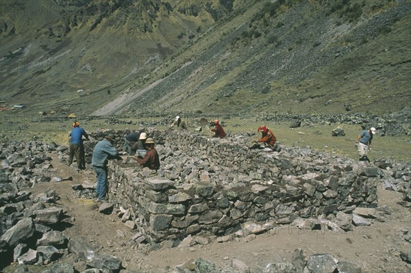 PERU, Cusco, Cancha Cancha, Local Quechuan men building a house.