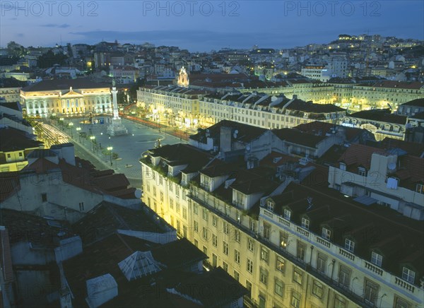 PORTUGAL, Lisbon, Baixa.  Praca dom Pedro IV at night with illuminated buildings and light trails from passing traffic.