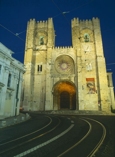PORTUGAL, Lisbon, Alfama.  Se Cathedral exterior facade at night with two castellated bell towers and rose window.