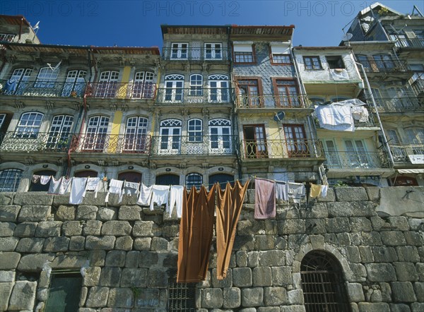 PORTUGAL, Porto, Oporto, Washing hanging from walls and balconies of waterfront houses in the Ribeira riverside quarter.