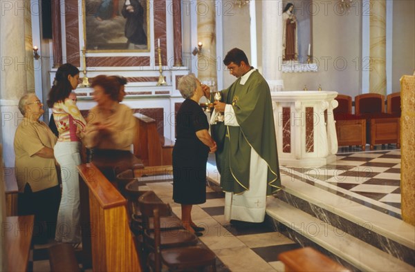 GREECE, Cyclades Islands, Syros, Ermoupolis. A Catholic service performed at the Church of Ag. Yiorgios.