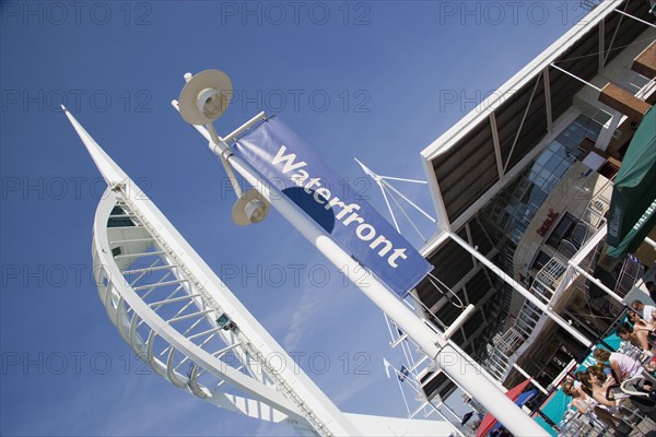 ENGLAND, Hampshire, Portsmouth, The Spinnaker Tower the tallest public viewing platforn in the UK at 170 metres on Gunwharf Quay with people sitting at tables outside waterfront restaurants