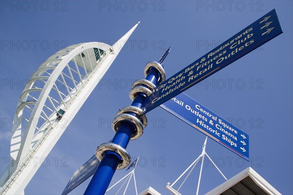 ENGLAND, Hampshire, Portsmouth, The Spinnaker Tower the tallest public viewing platforn in the UK at 170 metres on Gunwharf Quay with attractions signpost in the foreground